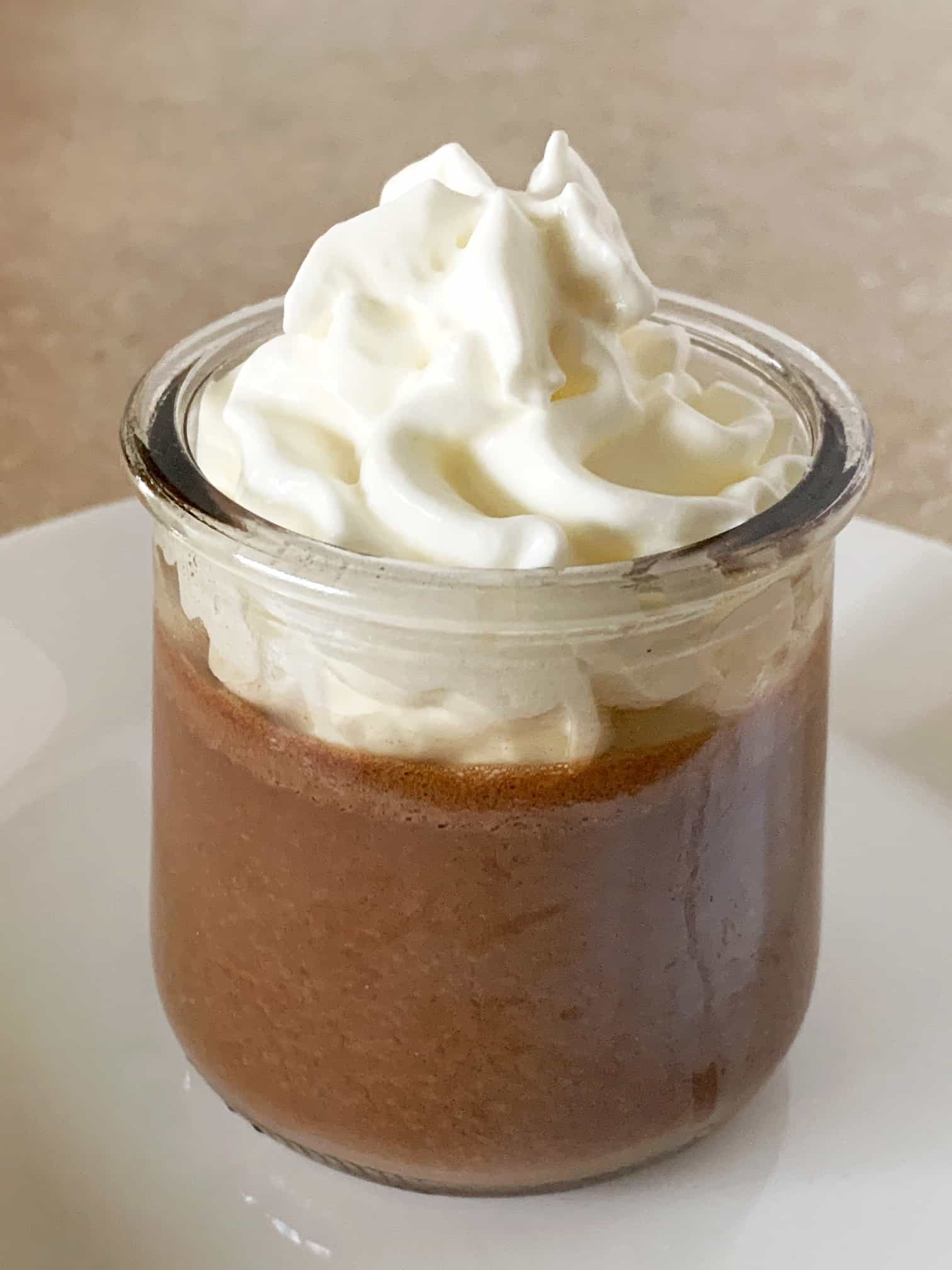 Pots de Creme topped with whipped cream in a glass jar