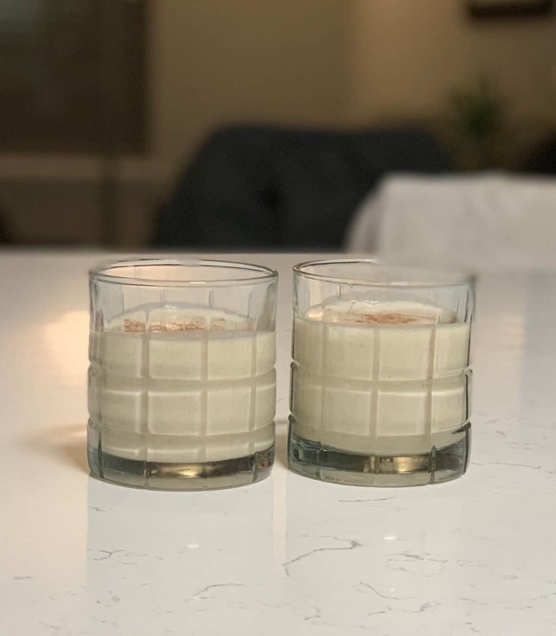 Two glasses of Authentic Puerto Rican Coquito garnished with cinnamon