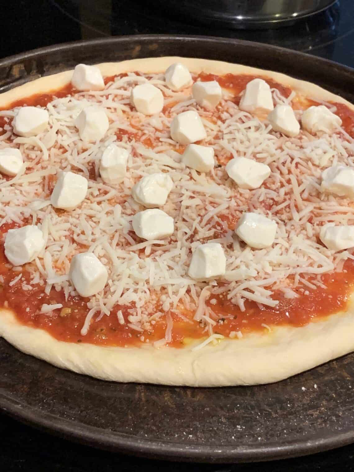 Bread Machine Pizza Dough topped with tomato sauce and fresh mozzarella