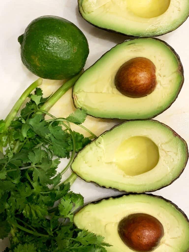 Avocado halves with cilantro and lime