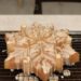 Almond snowflake cake glazed with brown butter on a wire rack