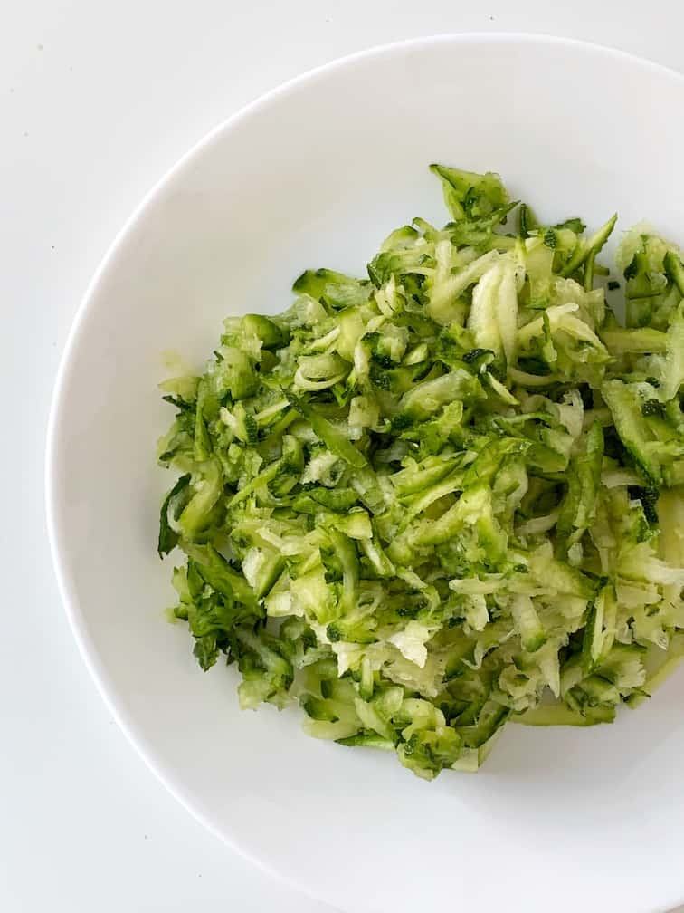 Grated zucchini on a white plate