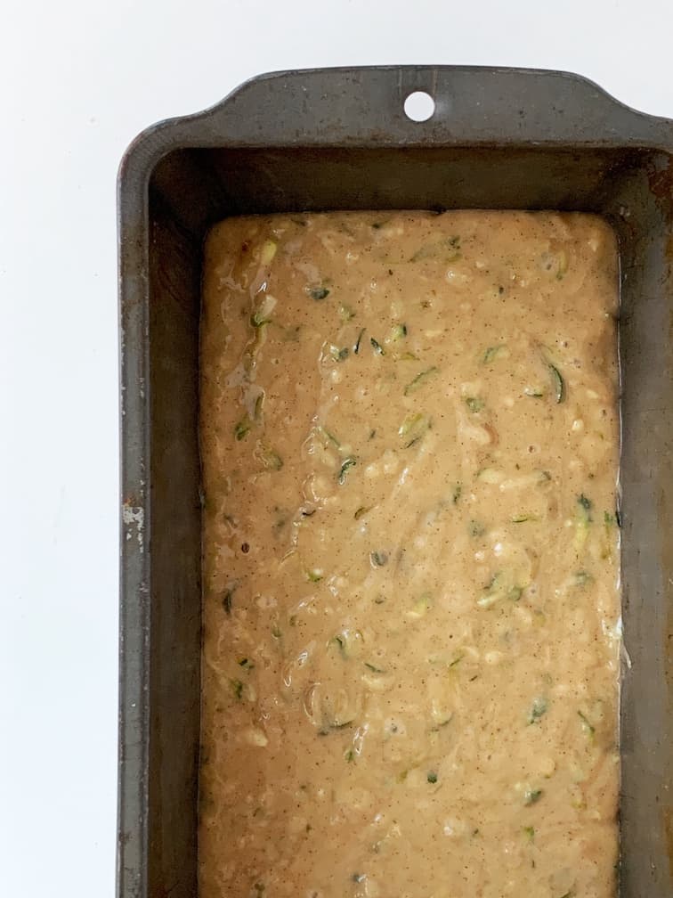 Zucchini bread batter in a a baking loaf pan, ready for the oven