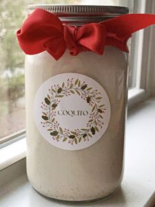 Coquito homemade gift, decorated with a red ribbon