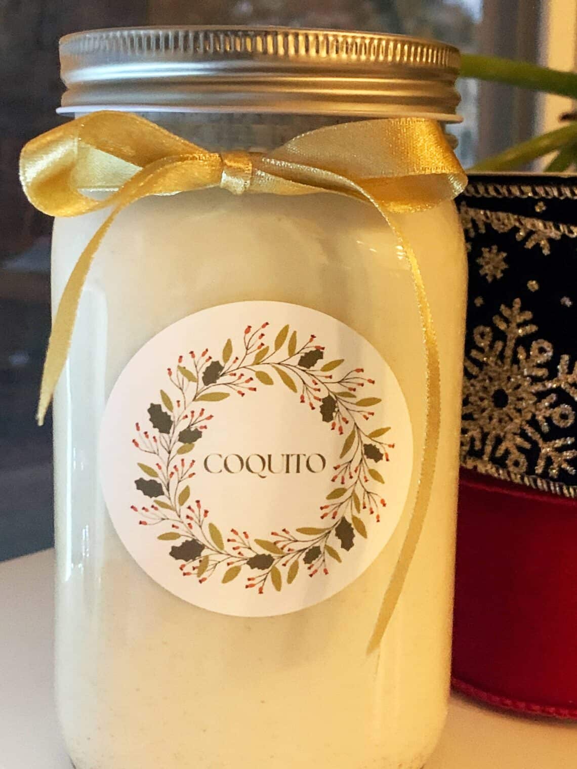 Homemade Coquito gift with a gold ribbon