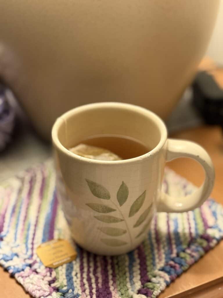 A cup of chamomile tea on a nightstand.