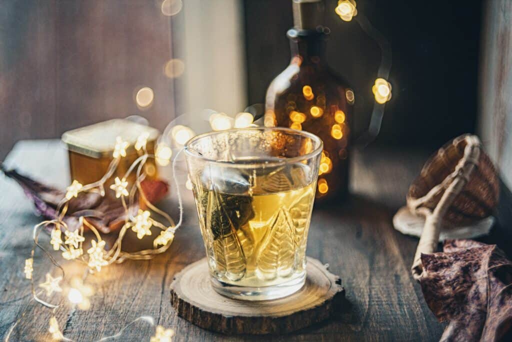 Tea in a clear glass with twinkling fairy lights in the background